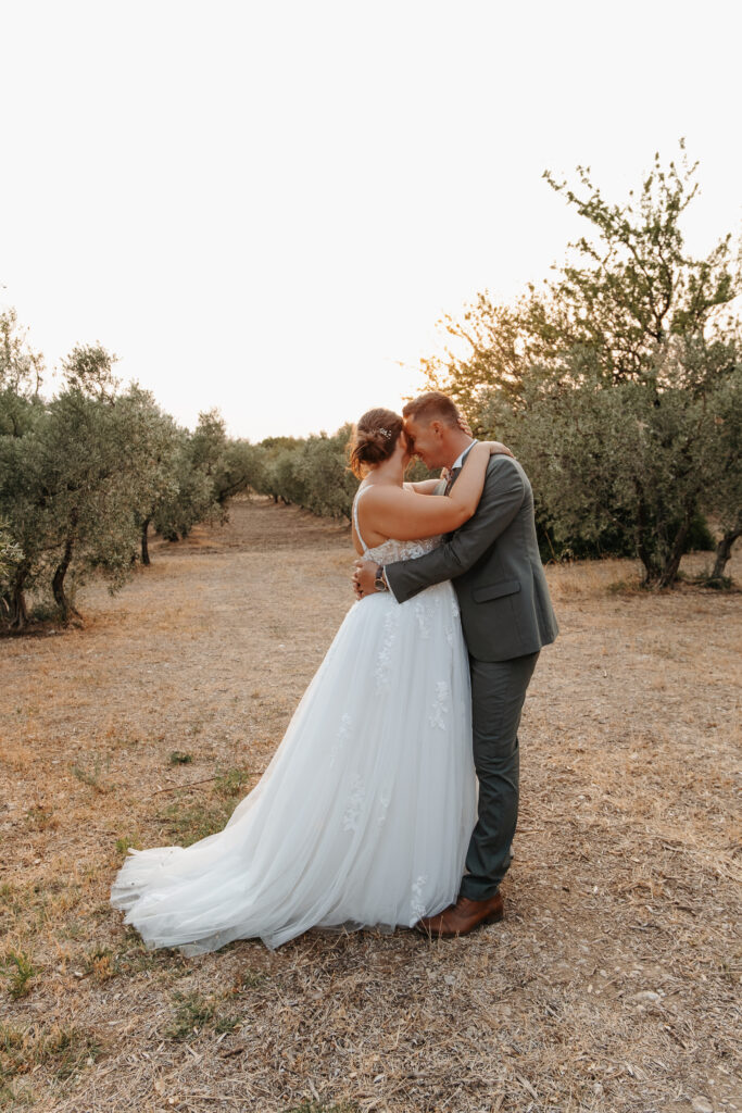 Couple de jeunes mariés venant de se marier à Mallemort dans les bouches du rhone, faisant des photos de couples à Eyguières avant de rejoindre leurs invités au Mas de Coupie photo prise en golden hour par Noélyne Di Muzio Photographie